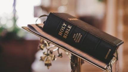A bible lies on a stand.