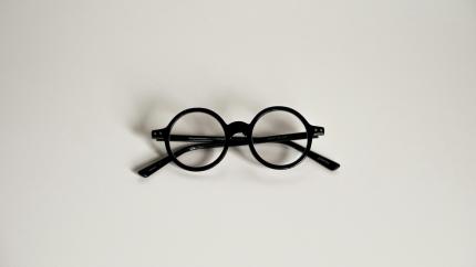A pair of glasses sits against a white background