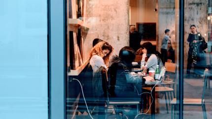A group of people sit together in a cafe and study