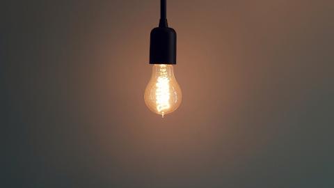 A lightbulb is shown on a dark background