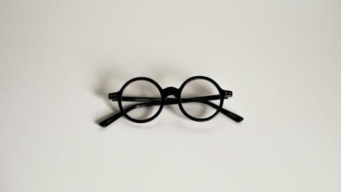 A pair of glasses sits against a white background
