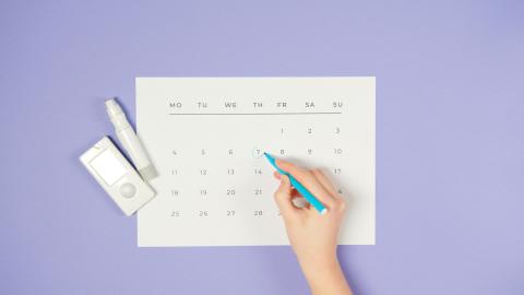 An image of a calendar on a purple background, with a person circling a date in the middle of the calendar