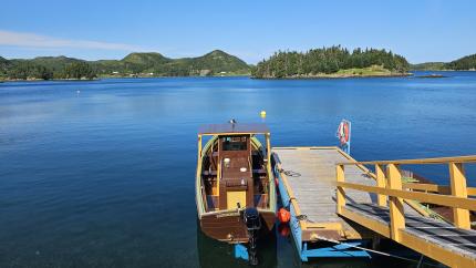 A boat sits on a beautiful lake surrounded by hills.