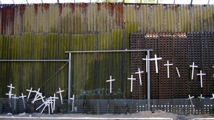 A border wall is adorned with crosses. Courtesy of Andrew Oppong.