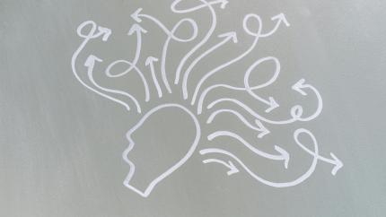 Image of the outline of a head drawn on a chalkboard, with multiple arrows drawn out from the main face. Courtesy of Pexels.