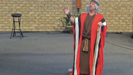 Image of a man preaching scripture while acting.