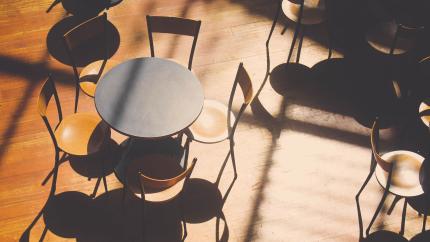 Image of a table against a wood floor background. Courtesy of Pexels.