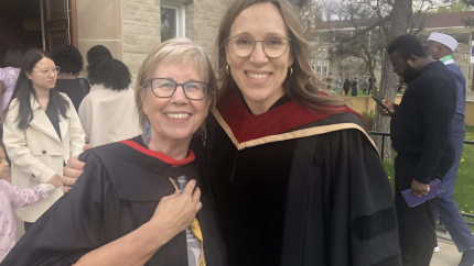 Two women stand together, wearing their robes for a graduation ceremony. Courtesy of Marlene Wolters and Do Justice.
