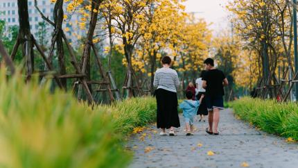 An image of a family walking along a path. Courtesy of Pexels.