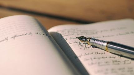 Image of a notebook open and a fountain pen. Courtesy of Unsplash.