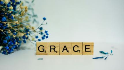 A photo with the words "grace" on a white background with blue flowers on the left side