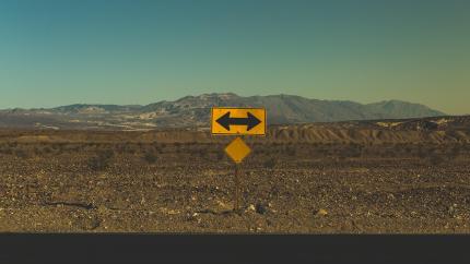 A road sign indicates a point at which a decision to turn must be made. Courtesy of Pexels.