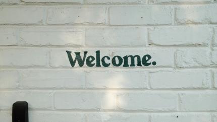Welcome text on a white brick wall