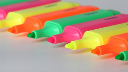 Highlighters in multiple neon colors on a white background