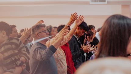 Individuals with lifted arms in prayer