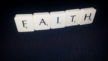 Scrabble letters form the word "Faith"
