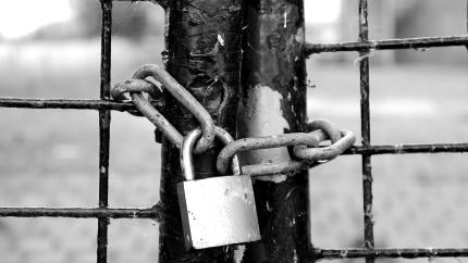 Image of a lock tied over a fence. Courtesy of Pixaby.