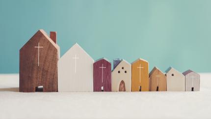 wood building blocks in the shape of churches are lined up next to each other with a wooden house block in the middle