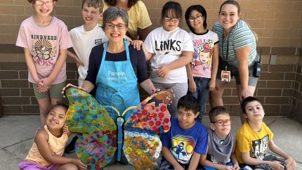 Pamela Alderman and a group of children with a butterfly art project they created together