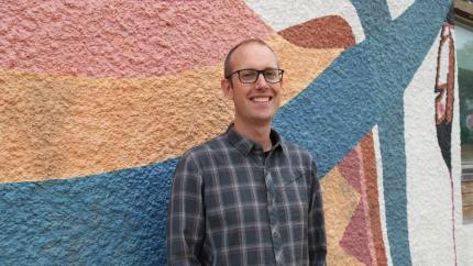 Al Postma, the Executive Dircteor of CRC Canada, stands against a painted background.