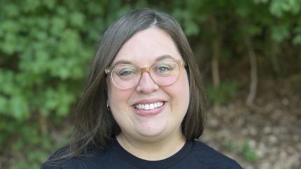 Headshot of Julia Rathburn, Thrive's Safe Church Consultant, against a green forested background.