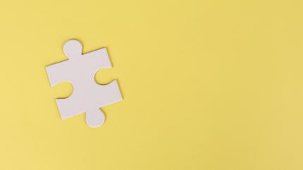 A single puzzle piece stands out on a yellow background
