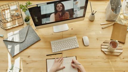 An image of a woman working on a computer during a Zoom call. Courtesy of Pexels.