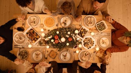 People gather around a table full of food