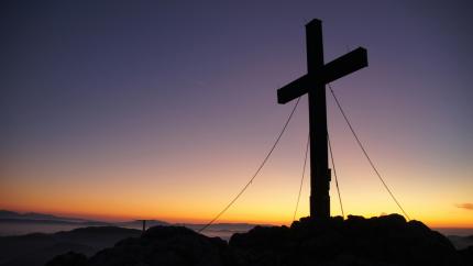 A cross stands against a beautiful dark blue background. Courtesy of Pexels.