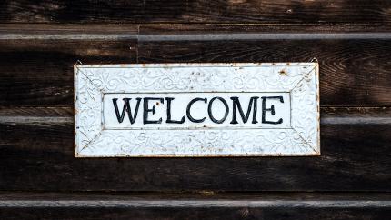 A sign that says "welcome" is present with a wood paneled background