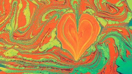 A heart shines on a multicolored painted background