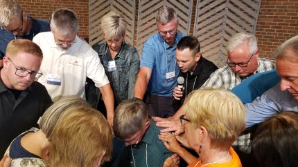 Leaders at synod pray over a pastoral candidate