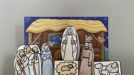 A small paper nativity scene is shown