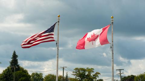 The American and Canadian flags stand next to each other. Courtesy of Pexels.