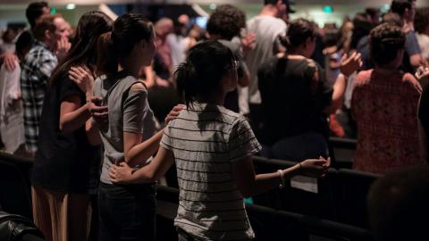 A group of people join together in a worship service. Courtesy of Pexels.