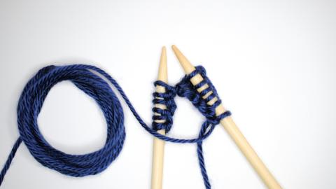 An image of blue knitting needles and yarn. Courtesy of Nik on Unsplash.