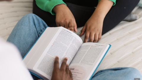 A girl reads a bible. Courtesy of GEMS.