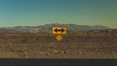 A road sign indicates a point at which a decision to turn must be made. Courtesy of Pexels.