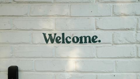 Welcome text on a white brick wall