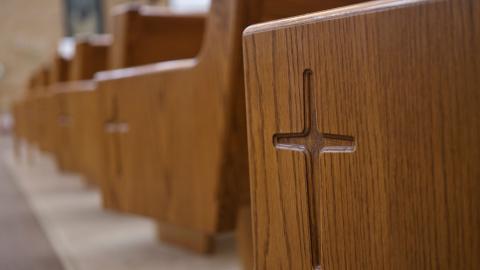 An image of a set of church pews with crosses on the outside. Courtesy of Pexels.