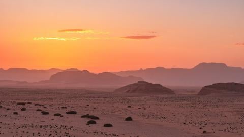 A desert landscape lit by orange sunlight