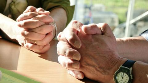 Two pairs of hands folded in prayer