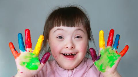 girl with big smile and paint all over hands!