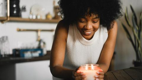 https://www.pexels.com/photo/cheerful-black-woman-with-burning-candle-at-home-5760943/