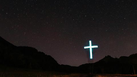 Image of a cross on a hill against a night sky. Courtesy of Pexels.