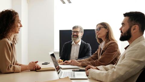 An image of a group of people sitting around a table. Courtesy of Edmund Dantes on Pexels.