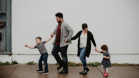 A family walks together in the rain. Courtesy of Emma Busto on Pexels.