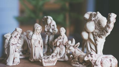 A nativity scene with white glass figures is shown