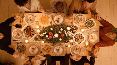 People gather around a table full of food