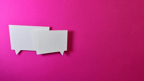 Two speech bubbles sit against a pink background.